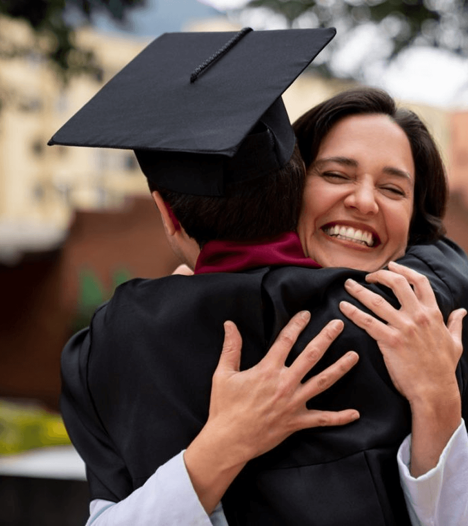 Madre abrazando a su hijo recién graduado.